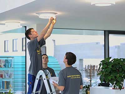 Elektriker arbeiten an einer Lampe